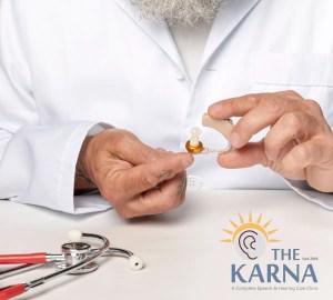 Close-up of an audiologist showing a hearing aid.